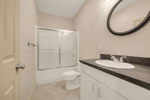 A bathroom with a toilet, sink, and shower.