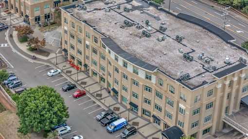 A parking lot in front of a large building.