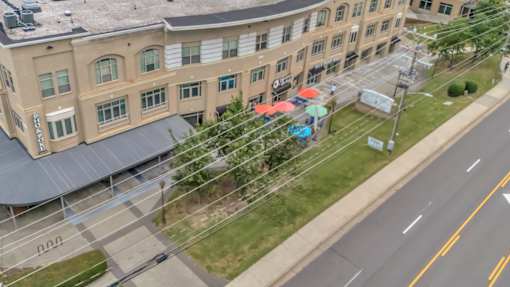 An aerial view of a building with a parking lot in front.