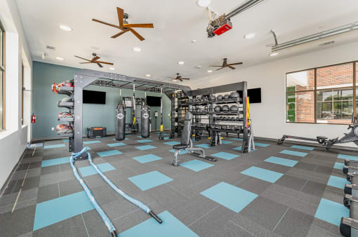 a spacious fitness room with weights and cardio equipment