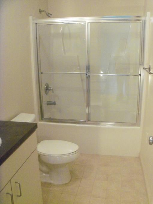 A white toilet sits in a bathroom next to a walk-in shower.