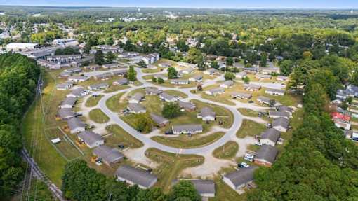 A bird's eye view of a residential area with houses and roads.