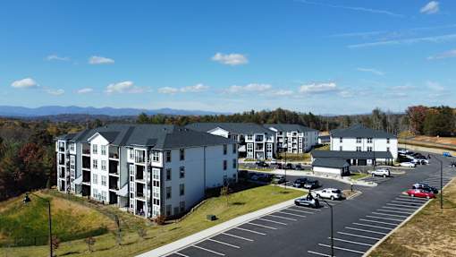 A large white building with a parking lot in front of it.
