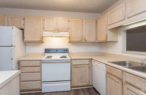 A kitchen with wooden cabinets and white appliances.