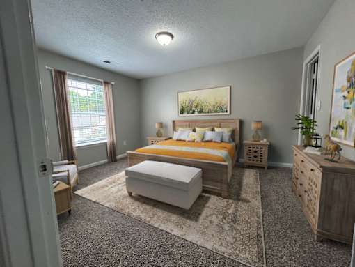 A bedroom with a bed, dresser, and window.