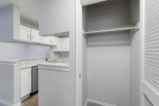 A kitchen with white cabinets and a marble countertop.