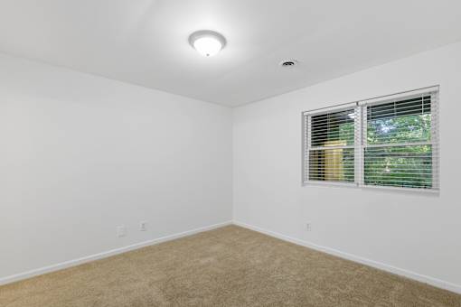 A room with a window and a ceiling light.