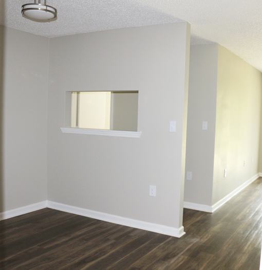 A room with a window and wooden floors.