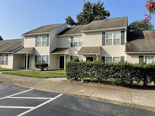 Apartment building with a parking lot in front.