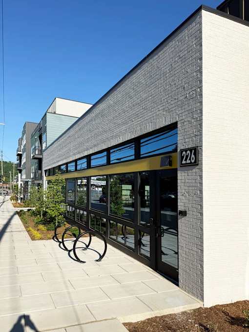A modern building with a glass entrance and a number 226 on the wall.