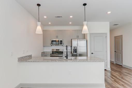 A kitchen with a granite countertop and white cabinets.