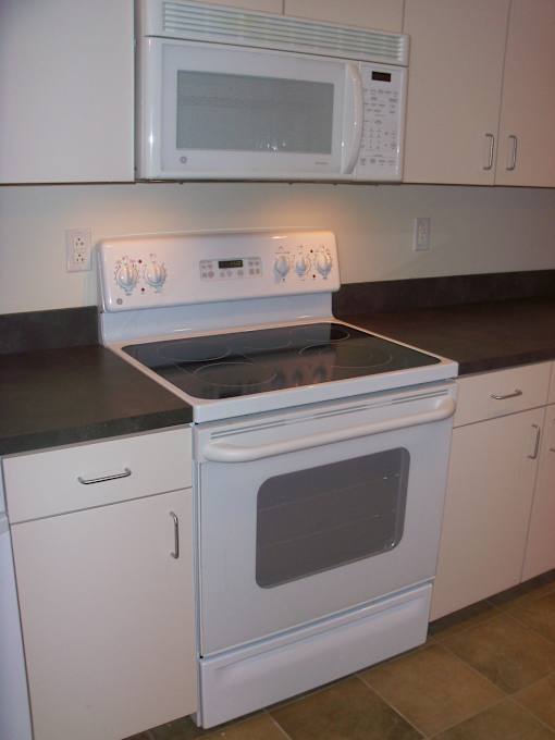 A white oven with a black top sits in a kitchen.