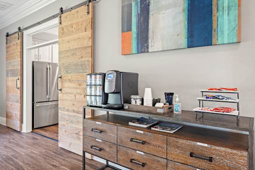 A kitchen with a wooden bar counter and a refrigerator.