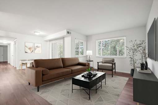 A living room with a brown couch, a coffee table, and a television.