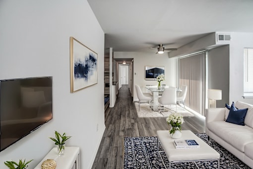 A living room with a white couch, a coffee table, and a painting on the wall.
