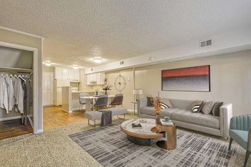 A living room with a grey couch, a coffee table, and a grey rug.