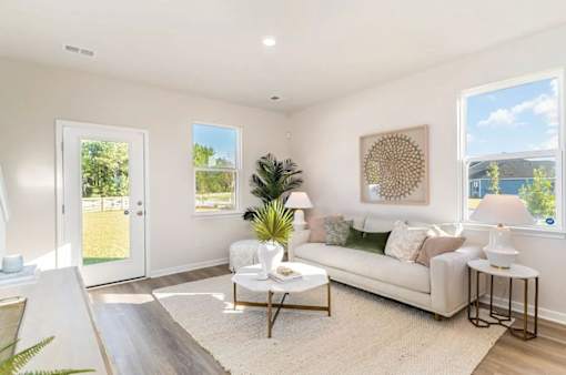 A well-lit living room with a white sofa and a coffee table.
