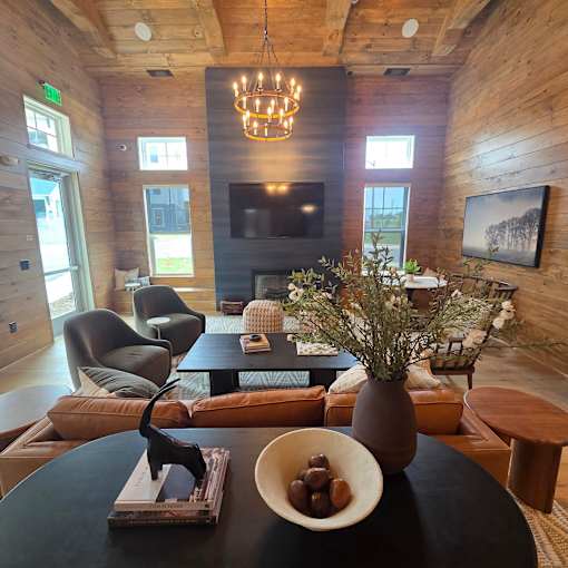 A modern living room with a black table and a chandelier.
