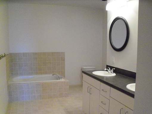 A bathroom with a white tub and sink.
