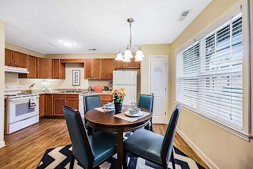 A kitchen with a table and chairs in the middle.