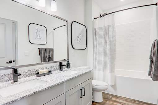 A bathroom with a toilet, sink, and shower curtain.