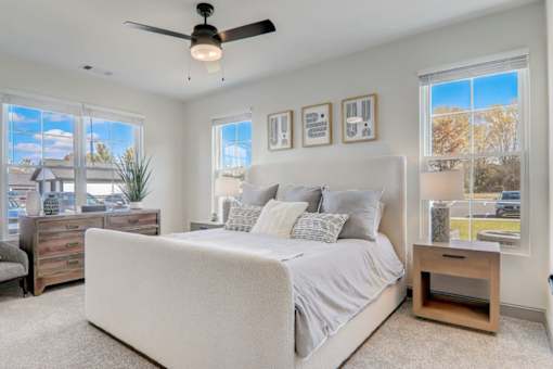 Dog-Friendly Garden-Style Apartments In Weaverville, NC - Highline North - Spacious Bedroom With Plush Carpeting, Ceiling Fan, And Multiple Windows For Natural Light