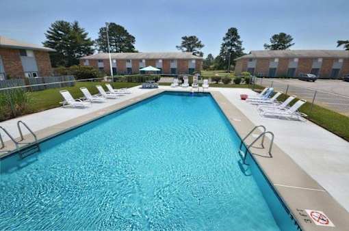 A large blue swimming pool with a no-diving sign.