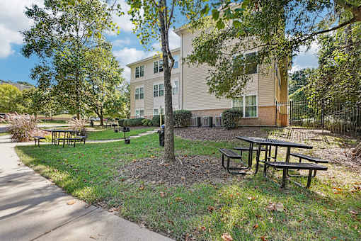 A tree in a grassy area in front of a building.