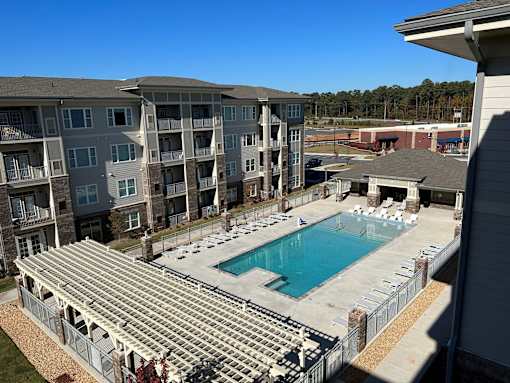 an aerial view of a swimming pool in front of an apartment building