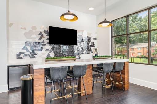 a kitchen with a long island with stools and a large window