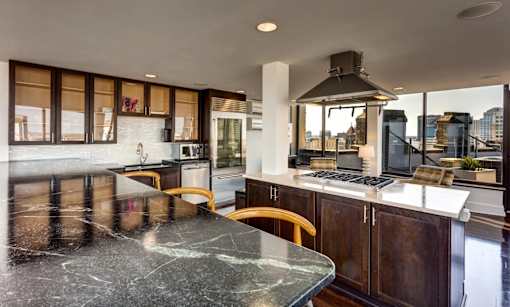 A modern kitchen with a large island and wooden cabinets.