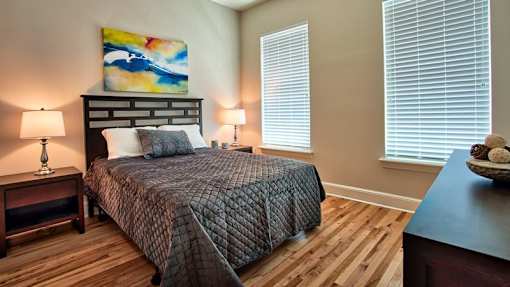 A bedroom with a large bed and a painting on the wall.
