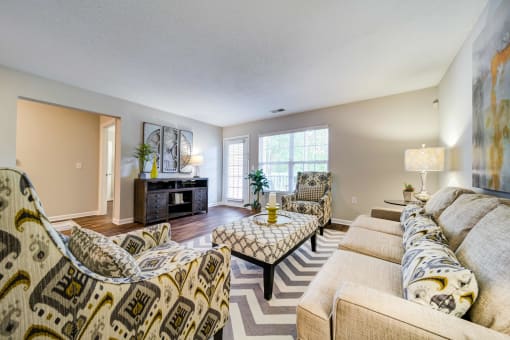 Large Living Room with Sofa, 2 chairs, Ottoman Coffee Table, Entertainment Stand, and Patio Door