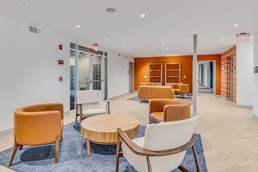 A room with orange chairs and a blue rug.