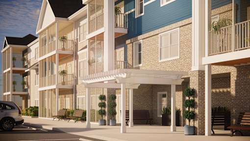 A modern apartment complex with a car parked in front.