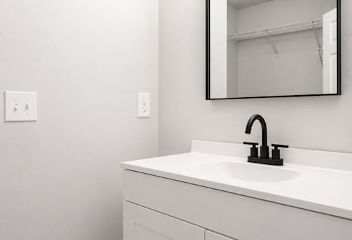 A white sink with a black faucet in a bathroom.