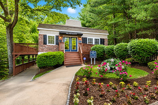 A small house with a blue door is surrounded by a garden.