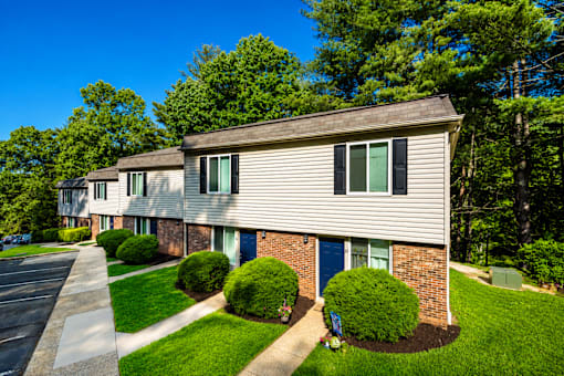 A row of houses with green bushes in front.