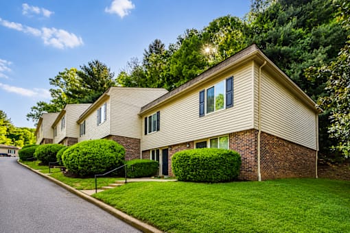 A house with a well-maintained lawn and a clear sky above.
