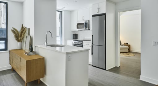 a kitchen with a white counter top and a stainless steel refrigerator