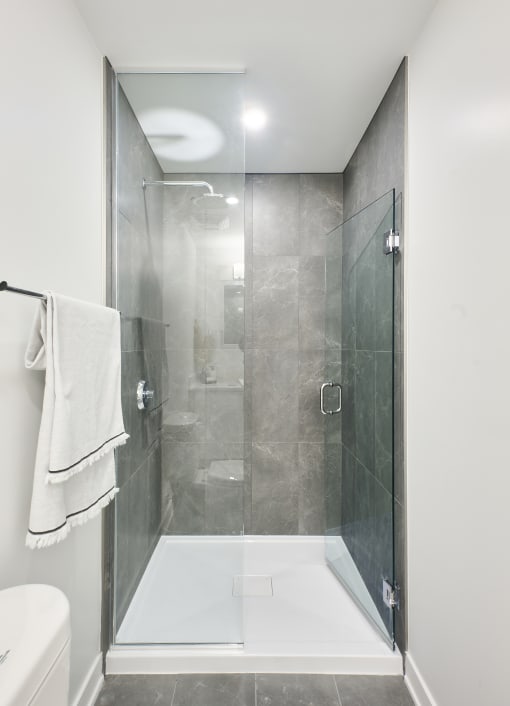 a bathroom with a shower and a sink and a towel