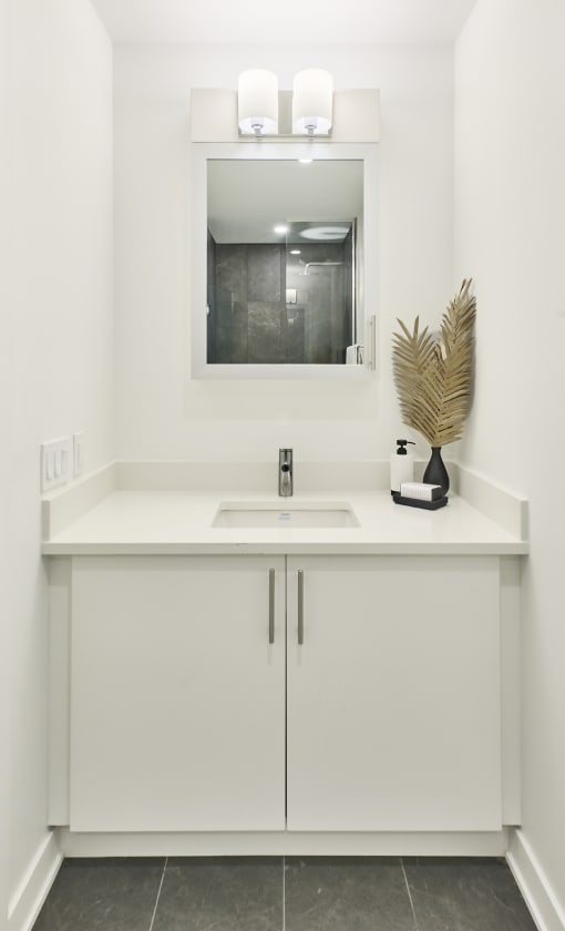 a white bathroom with a sink and a mirror