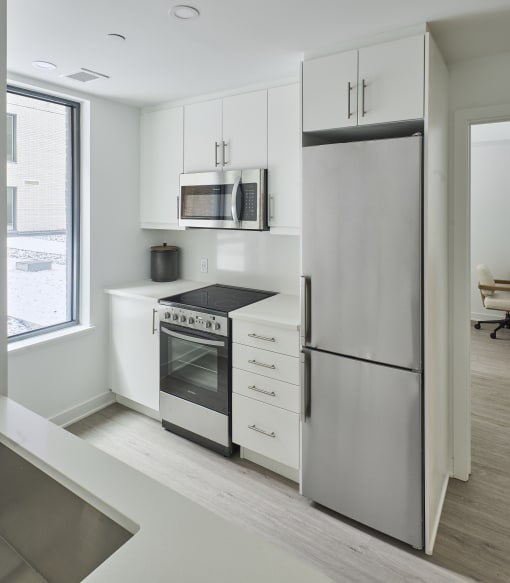 a kitchen with white cabinets and stainless steel appliances