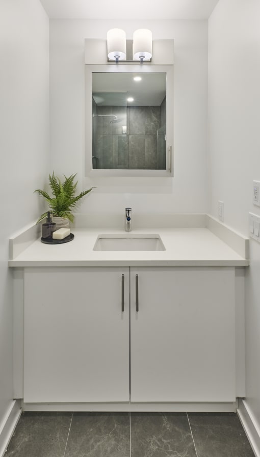 a white bathroom with a sink and a mirror