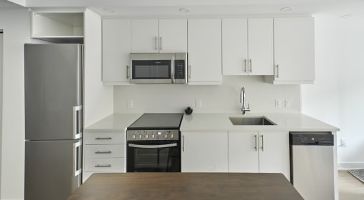 a kitchen with white cabinets and stainless steel appliances