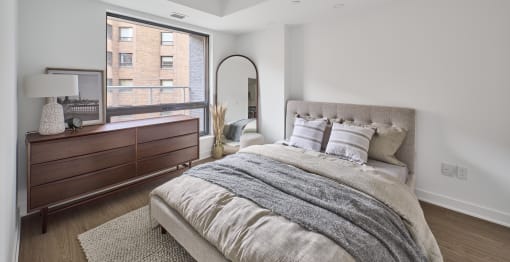 a bedroom with a bed and a large window