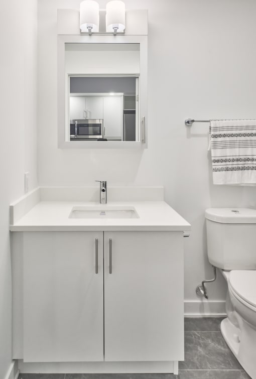 a white bathroom with a sink toilet and mirror