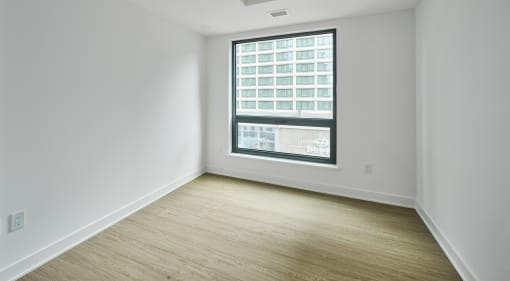 an empty room with white walls and a window