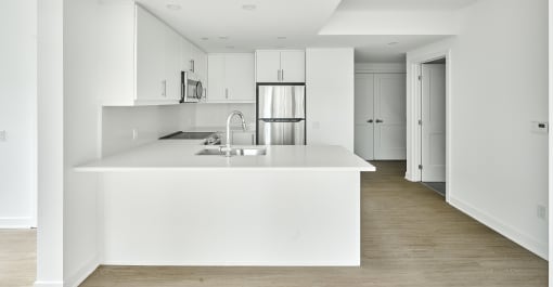 a large white kitchen with a white counter top and a white