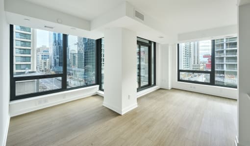 an empty living room with large windows and wood floors